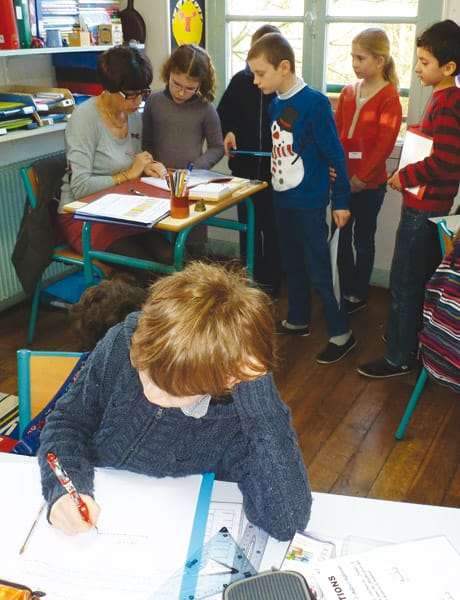 Les élèves qui ont achevé leur tâche en autonomie viennent faire vérifier leur travail par l’enseignante.